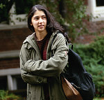 Woman with backpack standing with crossed arms