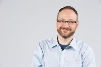 A person smiling for a professional headshot.