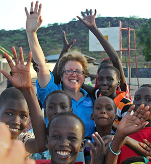 Caryl Stern of UNICEF in Africa with local children waving