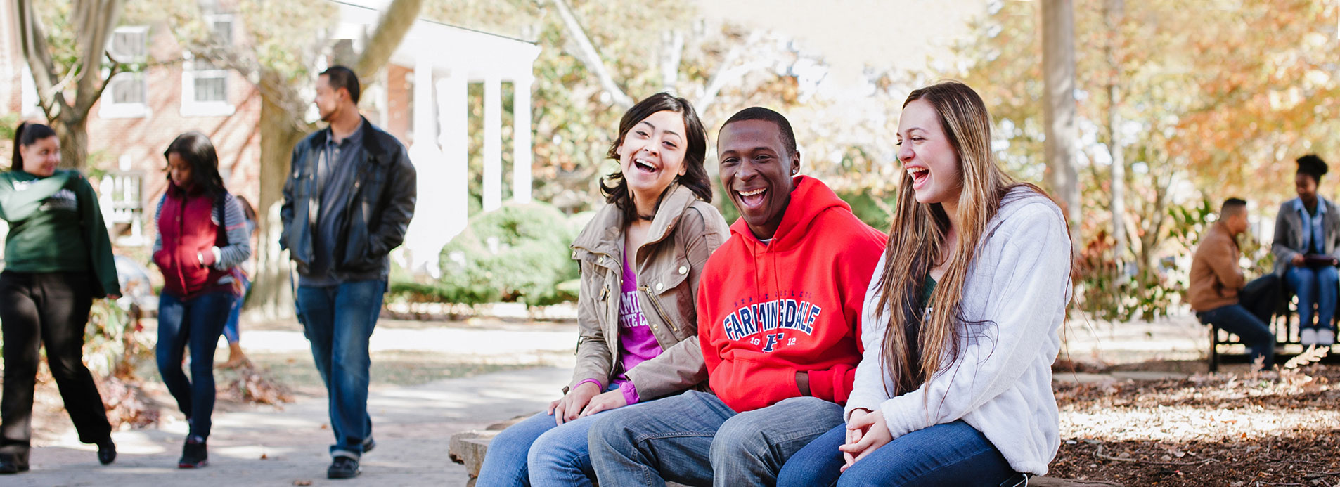 Farmingdale State College students sitting outside laughing.
