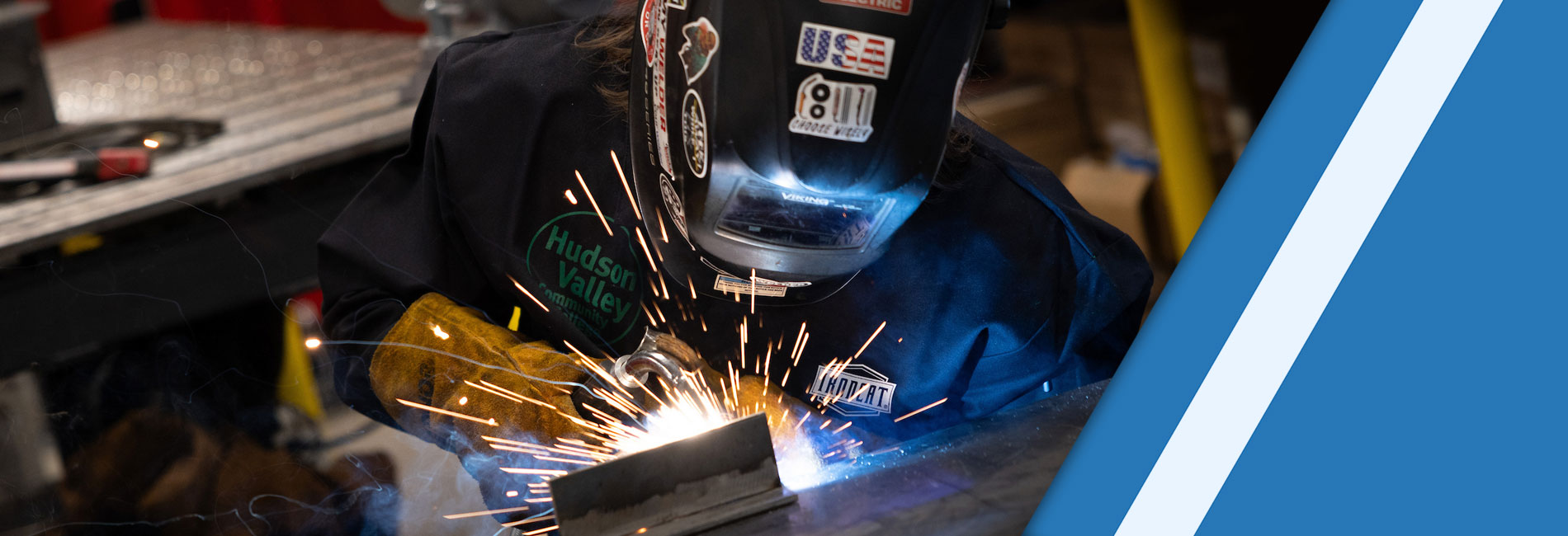 Person welding steel with full safety mask and suit on.