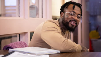 African American male studies at a table.