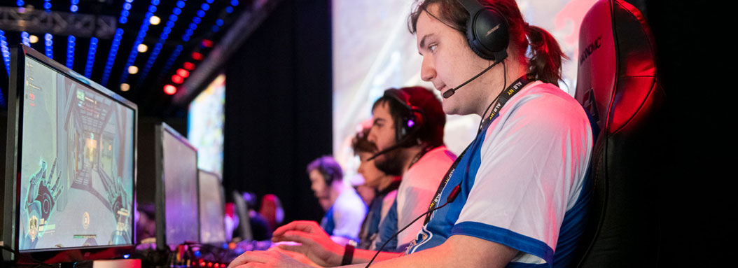 A male student competes in an esports competition with a headset on.