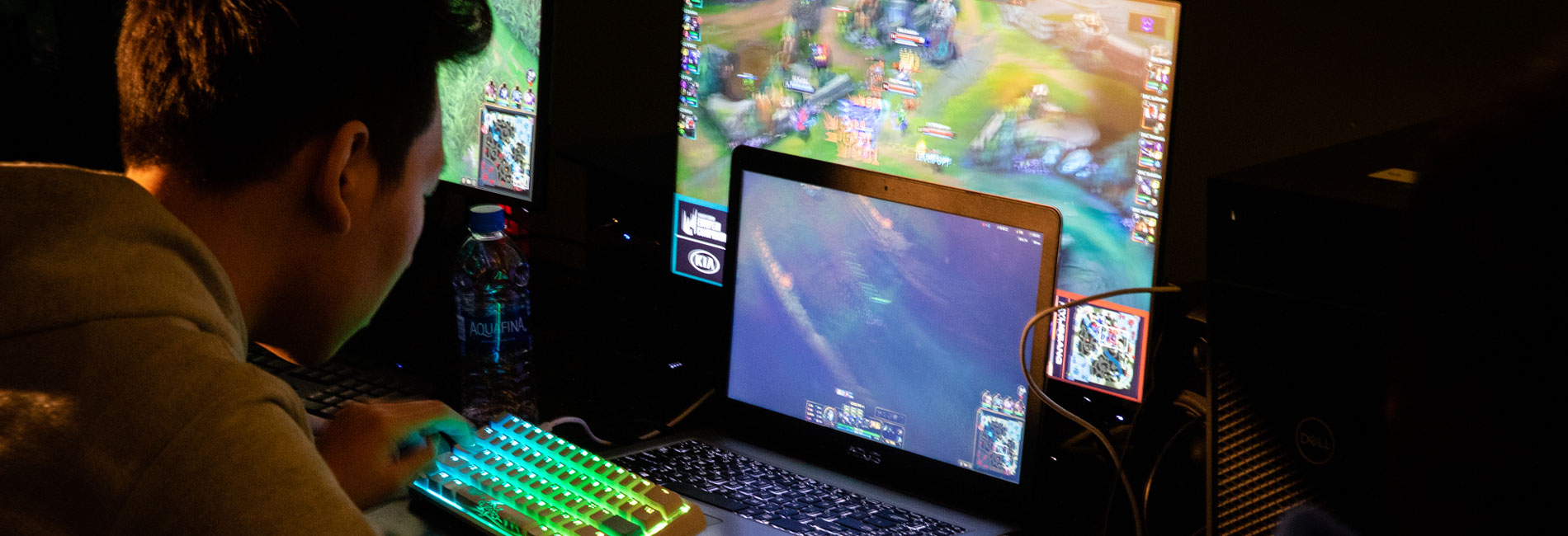 Young male student playing a video game in a dark room.