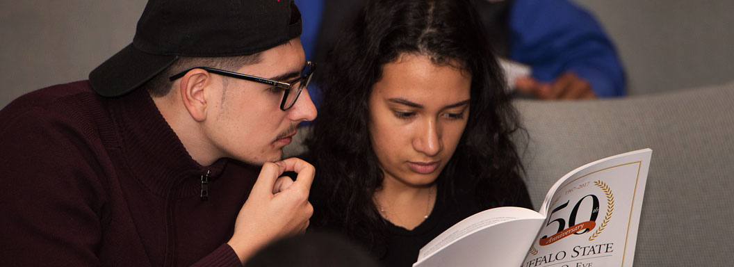A male and female student read an EOP booklet in a Buffalo State College lecture hall.