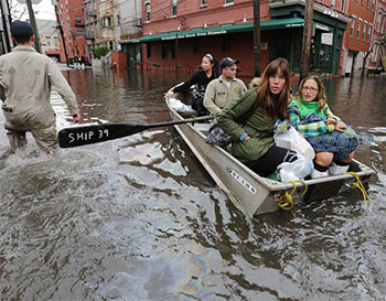 A rowboat from SUNY Maritime with people floating through the street to safety after Hurricane Sandy