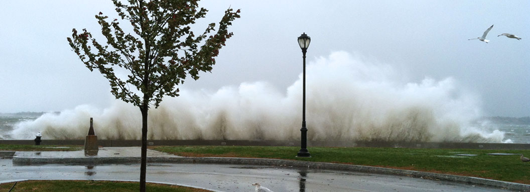 A wave crashes against a barrier near SUNY Maritime campus during Hurricane Sandy