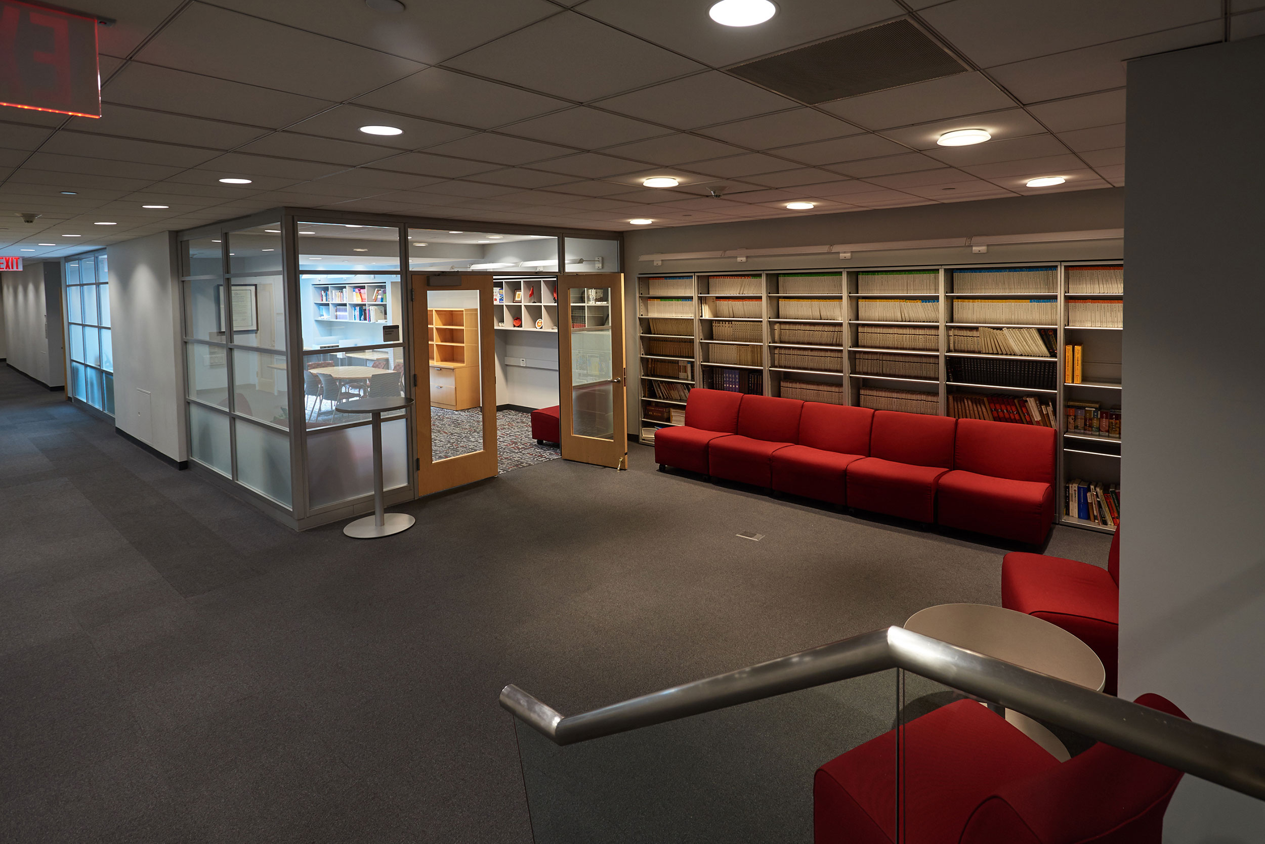 Long red couch along a wall in a common sitting area in the SUNY Global Center.