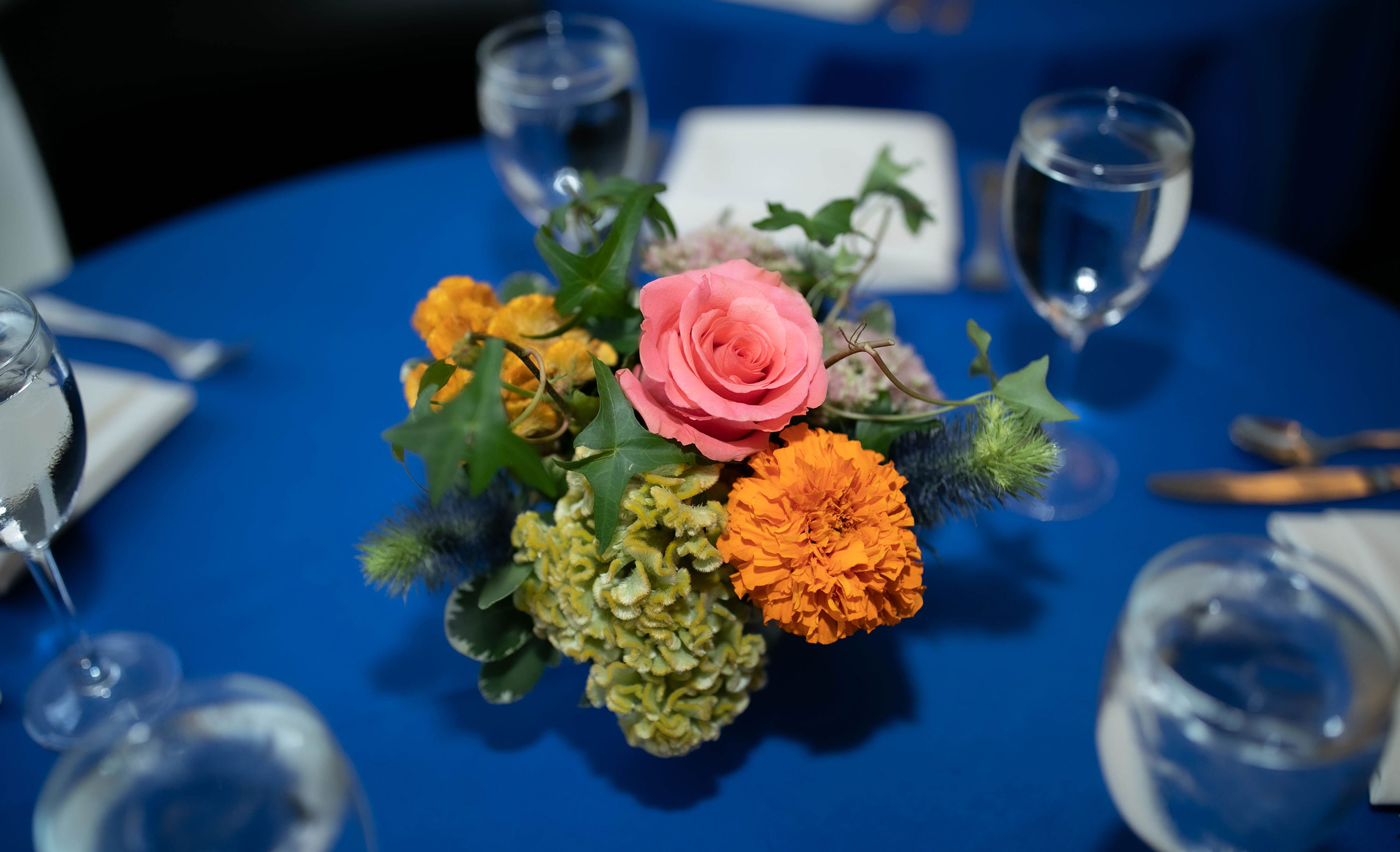 Flowers on top of a table with blue tablecloth.