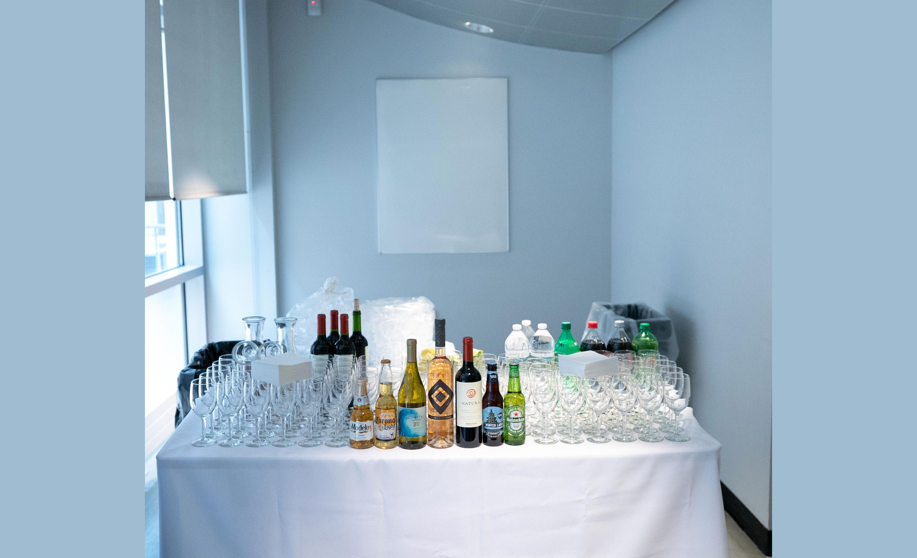 Bar station on white linen table along blue wall.	