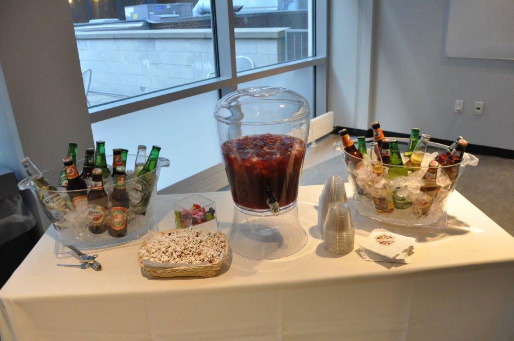 Bar station on white linen table in front of windows.
