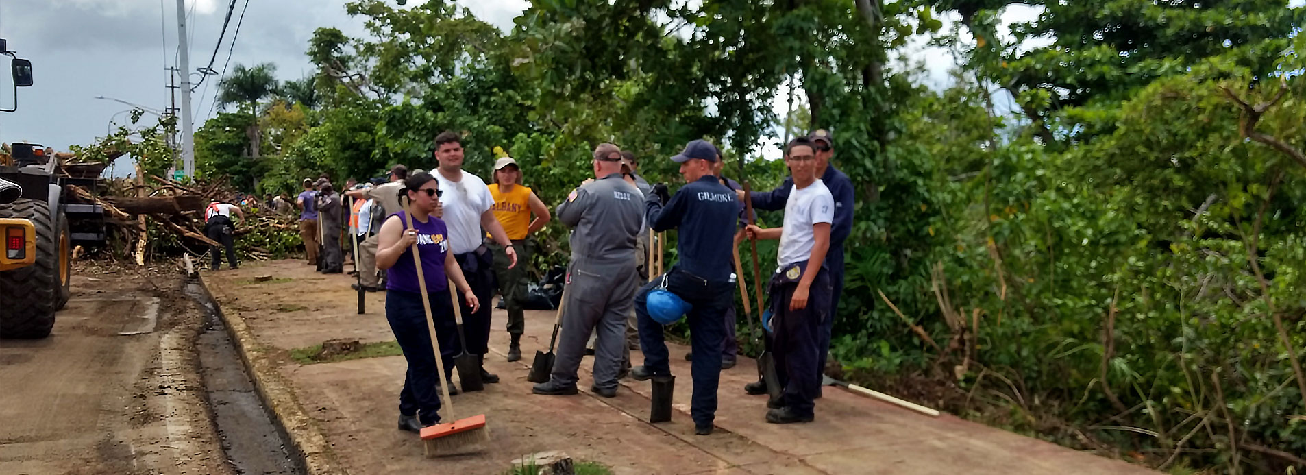 University at Albany students stand resting after clearing a road of debris in Puerto Rico. 