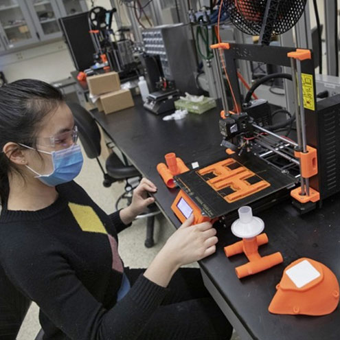 A female faculty member works on ventilator construction in a Binghamton University lab.
