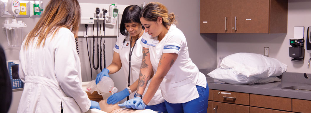 Nursing students work on a dummy in a nursing simulation lab.