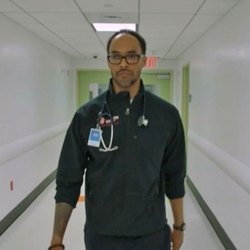 Downstate Medical Center's Dr Rob Gore walking down a hospital hallway.