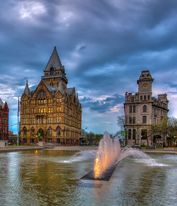 Reflecting pool in front of large old stone buildings in Clinton Square in downtown Syracuse NY