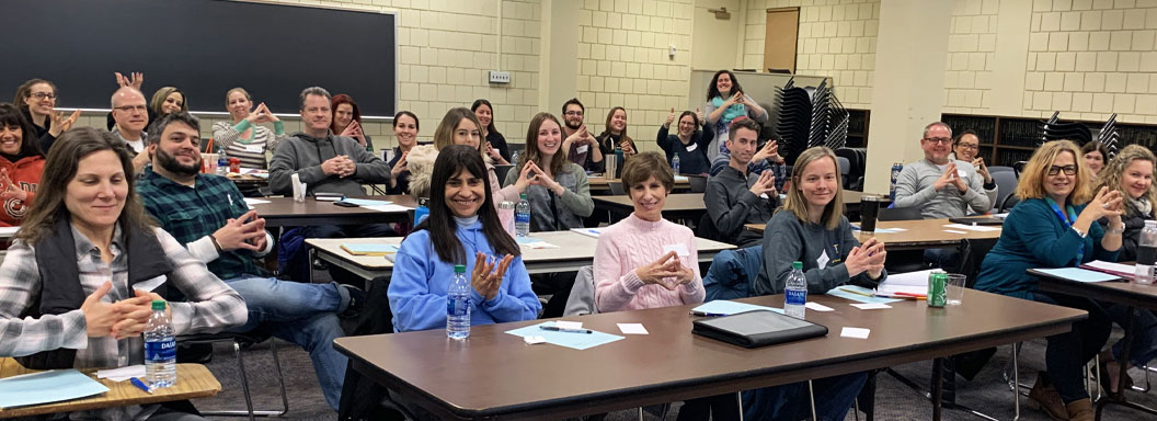 NYS educators sit at tables in a classroom as part of a development conference.