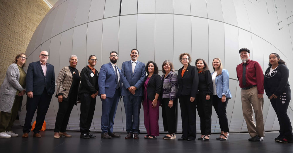 SUNY Chancellor John B. King Jr. stands with a group of Buffalo State University staff for a group picture.