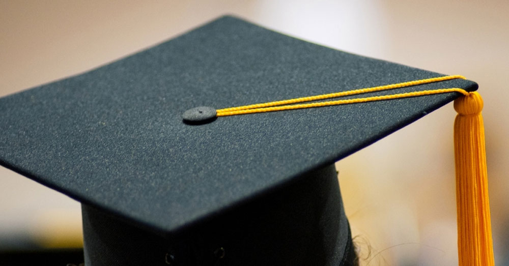 A black graduation cap with yellow tassel.
