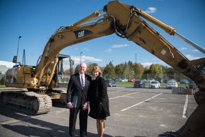 Chancellor Kristina Johnson stands with New Paltz President Christian in front of a giant excavator.