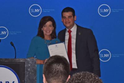 New SUNY Student Assembly president Marc Cohen stands with Lieutenant Governor Kathy Hochul at his swearing in ceremony.