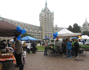People browse and shop for food and goods at the farmers market in front of SUNY Plaza.