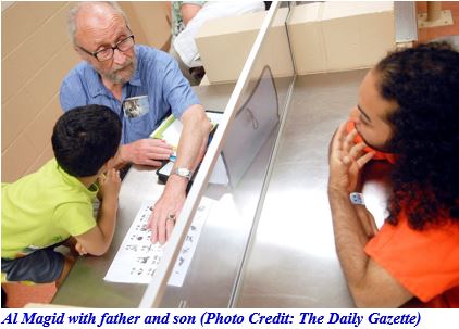 Photo of Al Magid, founder and executive director of the Reading Is Fun Program in Schenectady, NY with father and child