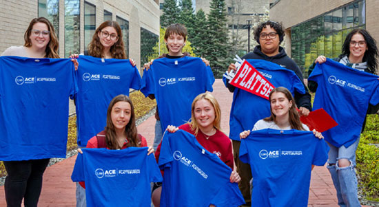 Students at SUNY Plattsburgh hold up blue ASAP|ACE tshirts.