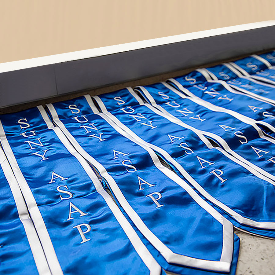 A series of blue SUNY ASAP ribbons lay flat on a counter top.