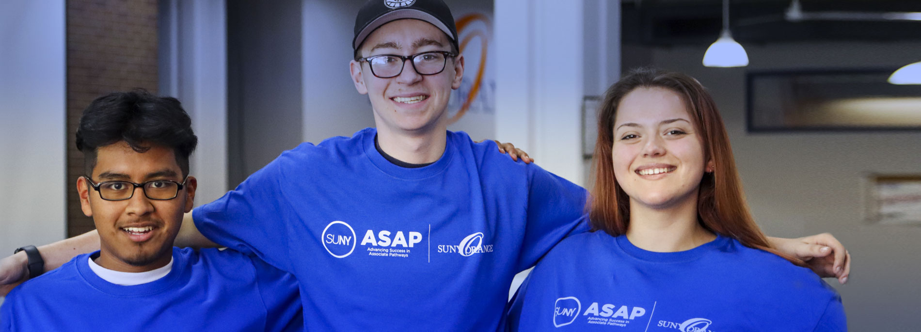 Three Orange County CC students wearing blue tshirts with SUNY ASAP logo on them.