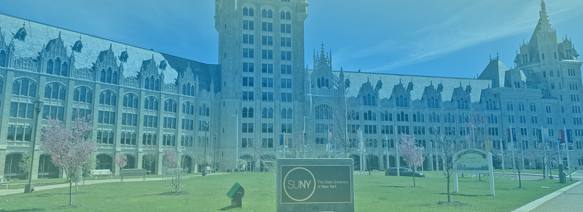Front of H Carl McCall SUNY Building with blue-green gradient over it. 