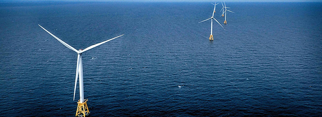 Wind turbines set up in deep ocean water.