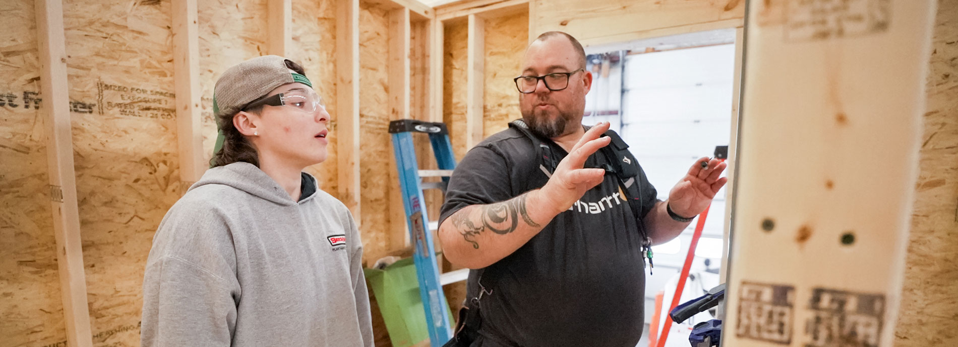 Two college students in a house under construction talk about their work on the construction site.