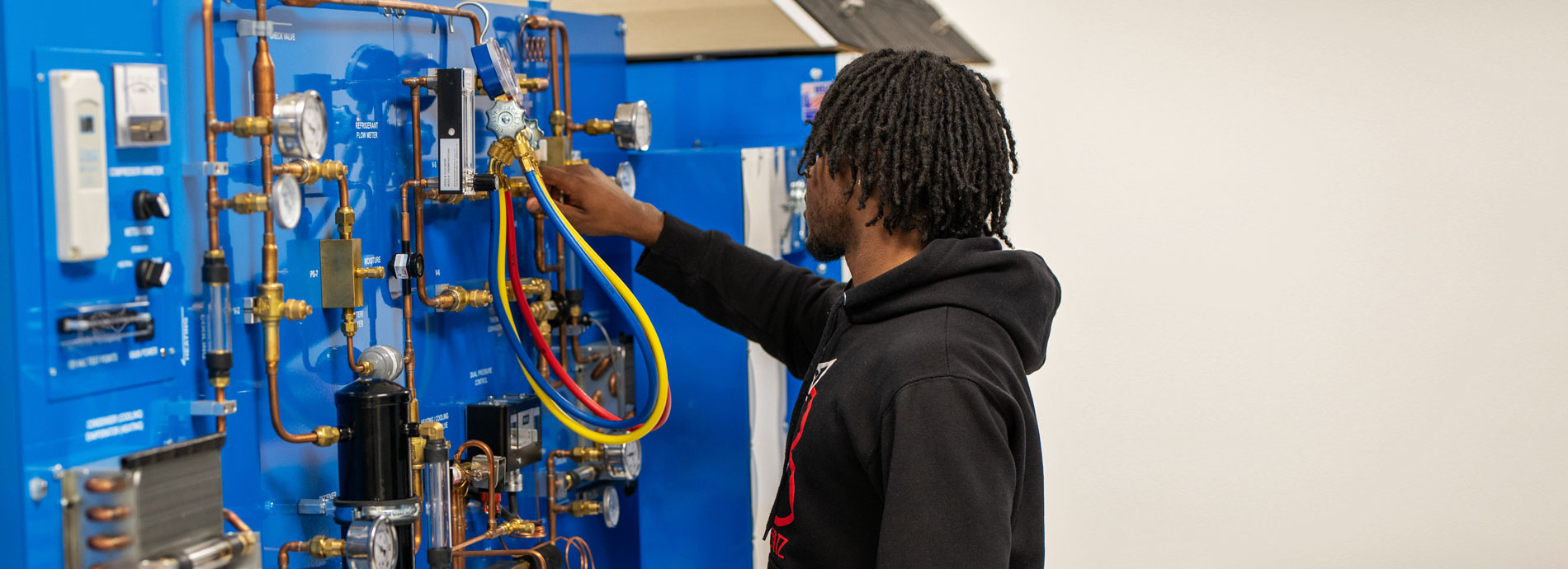 Male student works on HVAC system at Dutchess Community College